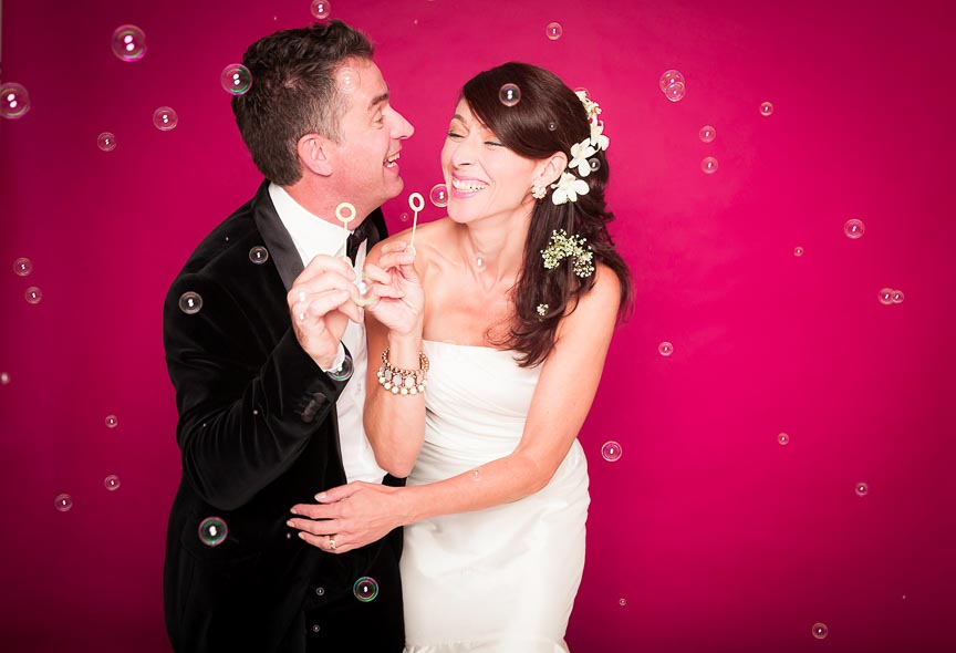 Photo of groom and bride having fun at the Photo Booth by Marili Clark Photographer.