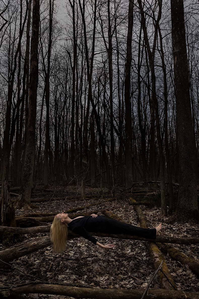 Le Repos de la Guerrière - Woman lying on a fallen tree in the forest.