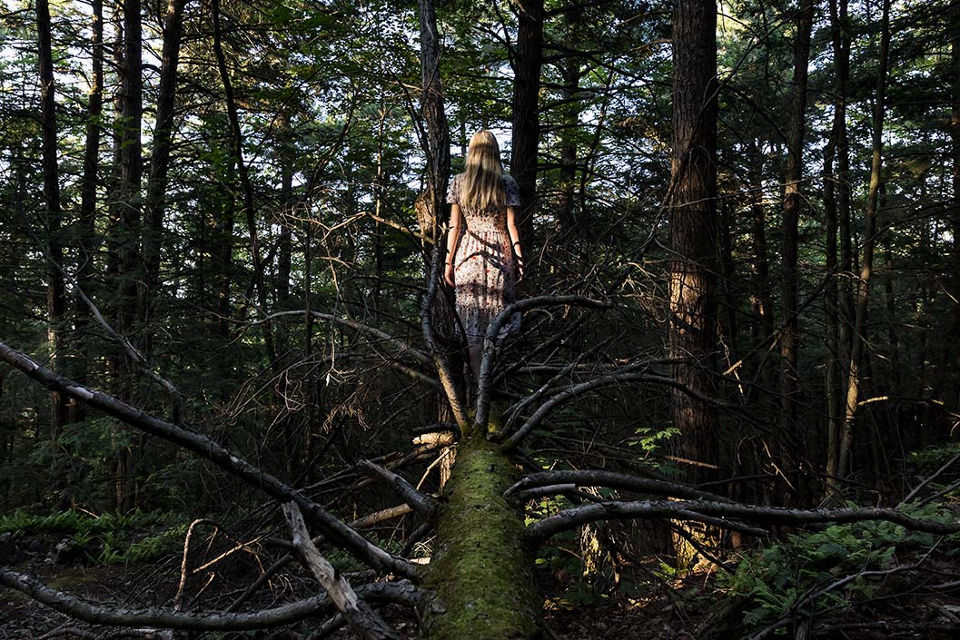 Le Repos de la Guerrière - Out on a Limb - Woman walking along the trunk of a fallen tree in the forest.