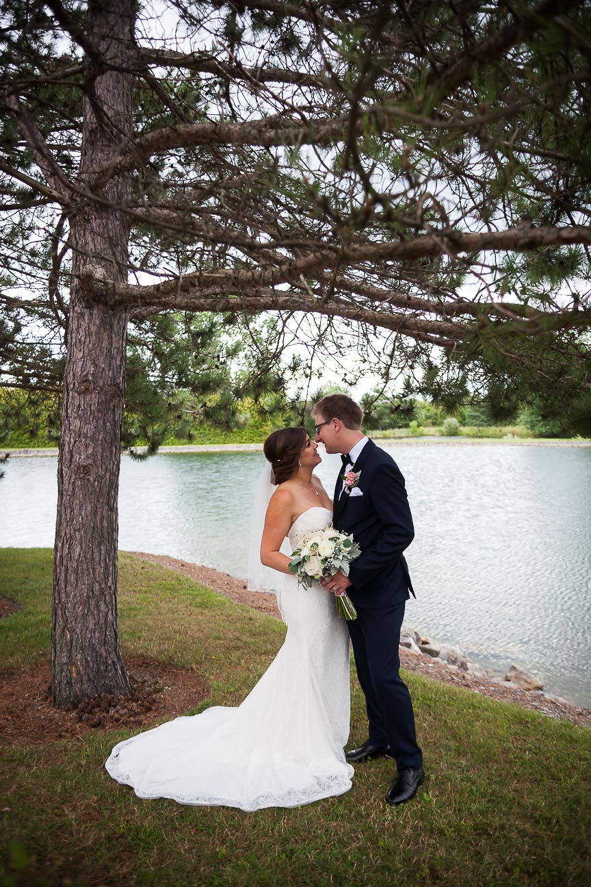 Photo of bride and groom in front of a lake by Marili Clark Photographer.